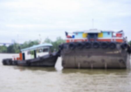 Tug boat towing a cargo boat in the river,Image blurred styleの写真素材