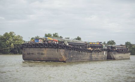 Tug boat towing a cargo boat in the riverの写真素材