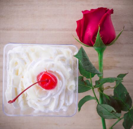 Red roses and cake on background woodenの写真素材