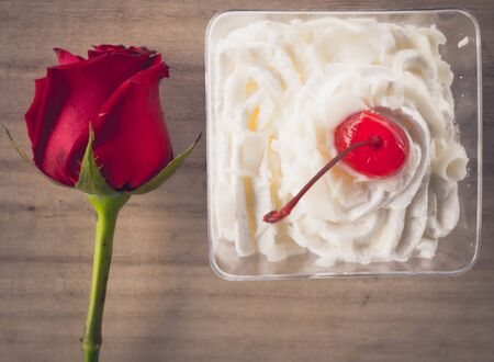 Red roses and cake on background woodenの写真素材