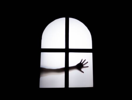 The silhouette of a human in front of a door at night.Scary scene Halloween concept of blurred silhouetteの写真素材