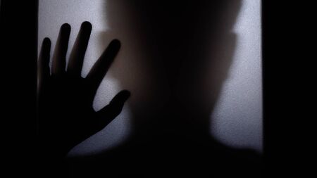 The silhouette of a human in front of a door at night.Scary scene Halloween concept of blurred silhouetteの写真素材
