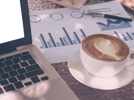 Blank white laptop screen display on the table with a cup of coffeeの写真素材