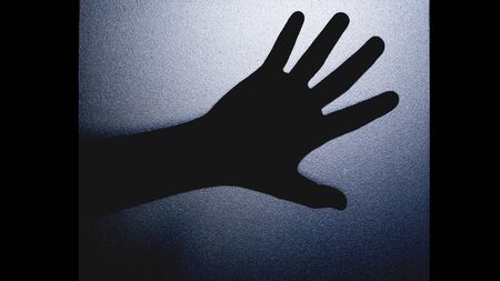 Shadow hand behind the mirror door. Halloween concept is background in black and white tone picture...