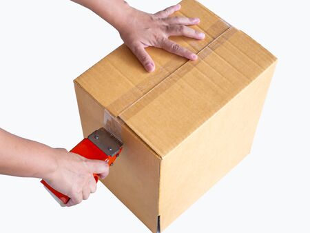Hand holding roll of clear plastic packing tape and brown box isolated on white background.の写真素材