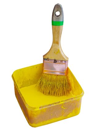 Old paint brush and yellow color on white backgroundの写真素材