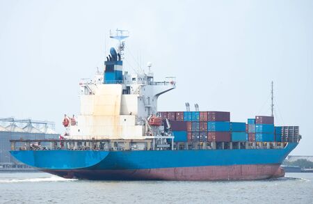 commercial container ship on river with dramatic skyの写真素材