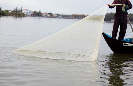 casting a net to catch fish This is the daily work of people from fishing village lakesideの写真素材