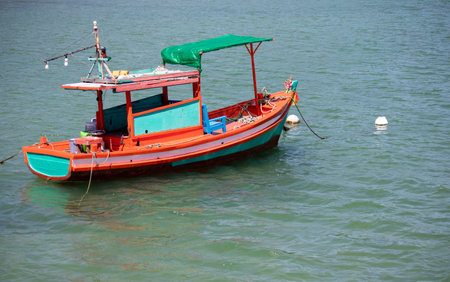 A lonely wooden small fishing boat on the very shoreの写真素材