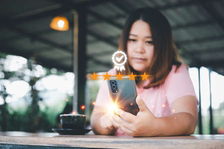 Customer experience concept. asian women using a smartphone sitting in a coffee shop Showing an...