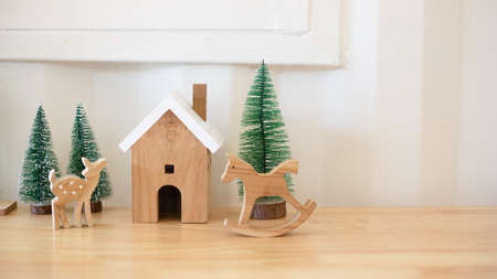 Modern design small wooden house with Christmas tree and deer, wooden horse. Welcome Christmas.の写真素材