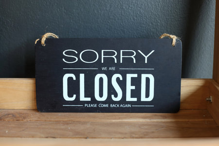 "Sorry we are closed" message board placed and please come back again on a wooden shelf.の写真素材