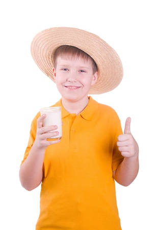 Happy young boy with  straw hat  and glass of milkの写真素材