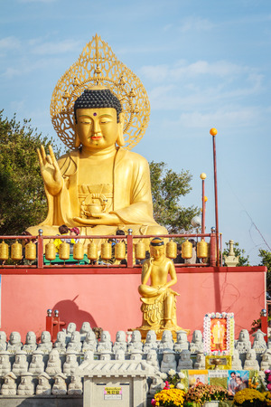 Gold Giant Buddha, Main Buddha Statue at Sanbanggulsa Temple, Sanbanggulsa is in Jeju-Do, Jeju Island in South Koreaの写真素材