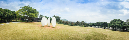 The Osulloc tea museum grass field garden outdoor view in panorama with mountain and blue sky background, the famous green tea museum in Jeju, South Koreaのeditorial素材