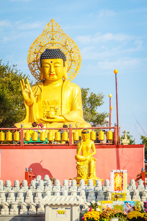 Gold Giant Buddha, Main Buddha Statue at Sanbanggulsa Temple, Sanbanggulsa is in Jeju-Do, Jeju Island in South Koreaの写真素材