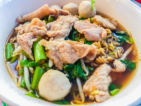 Popular street food in Thailand (Kuai Tiao Moo Namtok) that consisted of pork ball, pork meat, basil or thyme, bean sprouts, morning glory, noodle and creamy soup which favouring with sugar, fish sauce, chilli and vinegar marinadeの写真素材