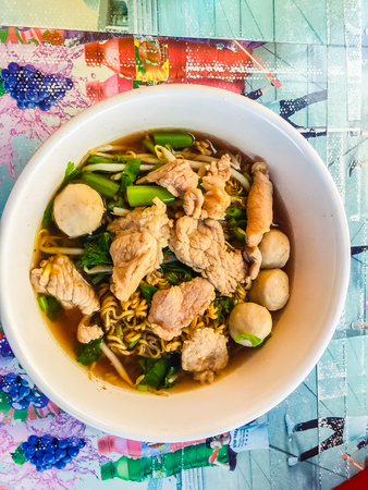 Popular street food in Thailand (Kuai Tiao Moo Namtok) that consisted of pork ball, pork meat, basil or thyme, bean sprouts, morning glory, noodle and creamy soup which favouring with sugar, fish sauce, chilli and vinegar marinadeの写真素材