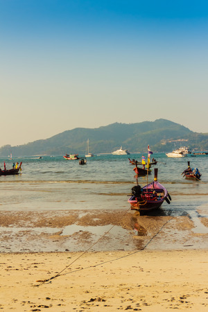 Beautiful scenery view of Patong beach in blue sky daylight and mountain background with local fisherman long tail boats and tourist luxury cruises. Patong is the popular beach in Phuket, Thailand.の写真素材