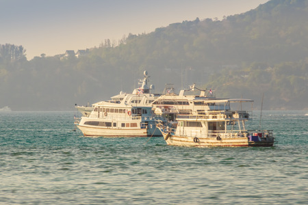 Beautiful scenery view of Patong beach in blue sky daylight and mountain background with local fisherman long tail boats and tourist luxury cruises. Patong is the popular beach in Phuket, Thailand.のeditorial素材