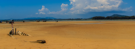 Old wreck fishing boat buried in the sand with blue sky on cloudy day backgroundの写真素材
