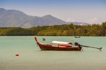 Fisherman boat and the Beautiful seascape view 
with blue sky and mountain on background at Phuket, Thailandの写真素材