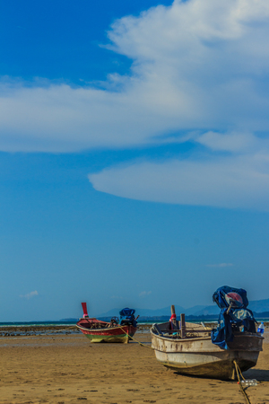 Fishing boats parking on the beach with blue sky background in the cloudy day.の写真素材