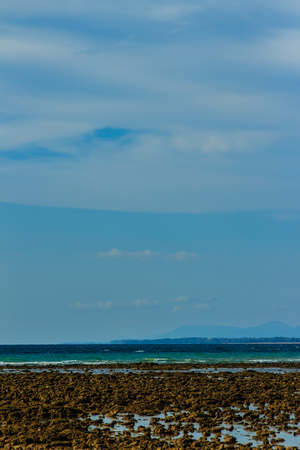 Beautiful rock stones on the beach when the sea water receded with dramatic blue sky background on the cloudy day.の写真素材