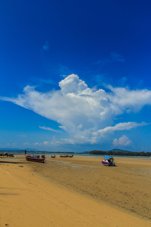 Fishing boats parking on the beach with blue sky background in the cloudy day.の写真素材