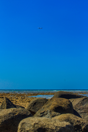 Beautiful rock stones on the beach when the sea water receded with dramatic blue sky background on the cloudy day.の写真素材