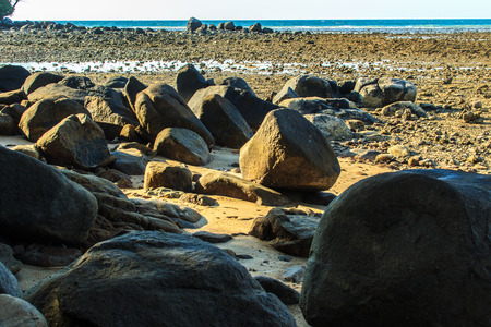 Beautiful rock stones on the beach when the sea water receded with dramatic blue sky background on the cloudy day.の写真素材