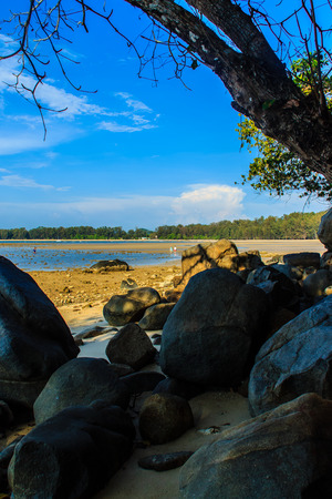 Beautiful rock stones on the beach when the sea water receded with dramatic blue sky background on the cloudy day.の写真素材