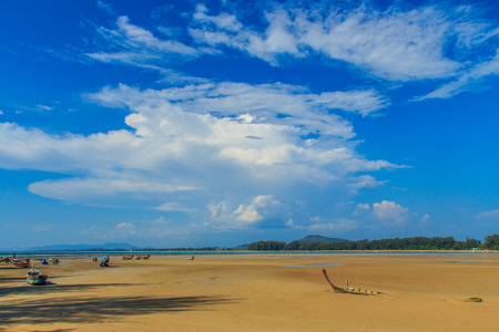 Old wreck fishing boat buried in the sand with blue sky on cloudy day backgroundの写真素材