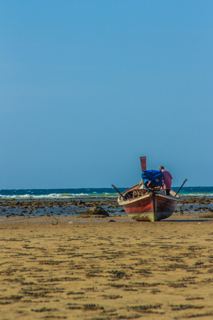 Fishing boats parking on the beach with blue sky background in the cloudy day.の写真素材