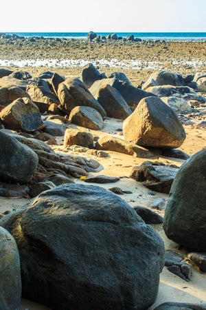 Beautiful rock stones on the beach when the sea water receded with dramatic blue sky background on the cloudy day.の写真素材