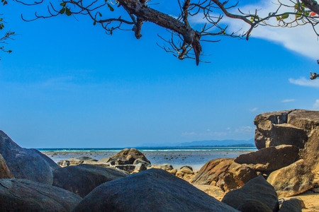 Beautiful rock stones on the beach when the sea water receded with dramatic blue sky background on the cloudy day.の写真素材