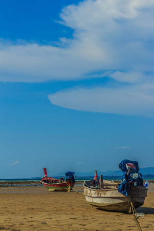Fishing boats parking on the beach with blue sky background in the cloudy day.の写真素材