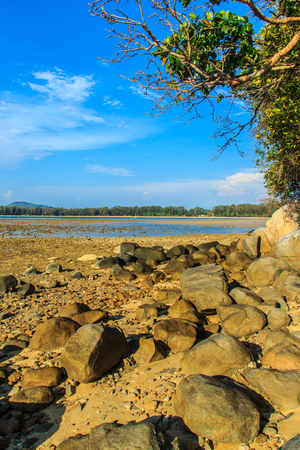 Beautiful rock stones on the beach when the sea water receded with dramatic blue sky background on the cloudy day.の写真素材