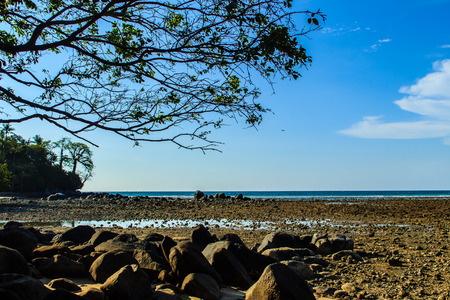 Beautiful rock stones on the beach when the sea water receded with dramatic blue sky background on the cloudy day.の写真素材