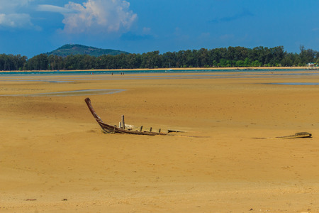Old wreck fishing boat buried in the sand with blue sky on cloudy day backgroundの写真素材