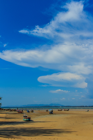 Fishing boats parking on the beach with blue sky background in the cloudy day.の写真素材