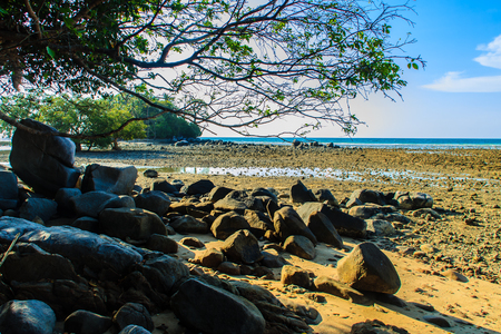Beautiful rock stones on the beach when the sea water receded with dramatic blue sky background on the cloudy day.の写真素材