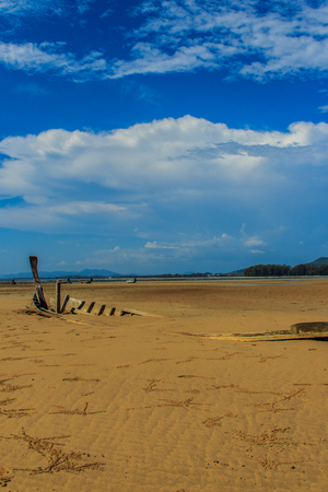 Old wreck fishing boat buried in the sand with blue sky on cloudy day backgroundの写真素材