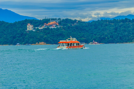 Beautiful Landscape of Sun Moon Lake in the morning with blue mountain background at Sun Moon Lake in Yuchi Township, Nantou County, Taiwanの写真素材