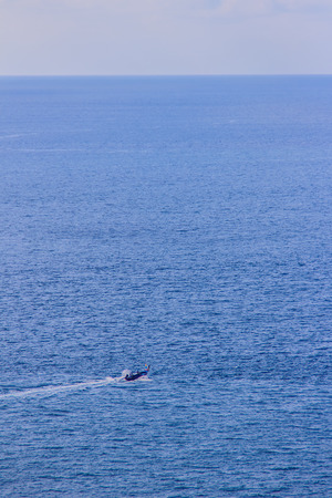 Colorful marine landscape with fisherman boat against deep blue sea under blue sky in the ocean on the cloudy day at Phuket, Thailand.の写真素材