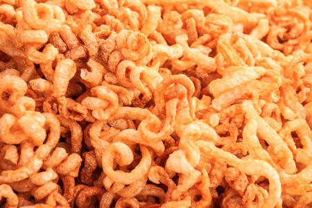 Close-up view of pork snack, pork rind, pork scratching, pork crackling. That is pork rind, leather or leather lean pork fried crispy and blistered. Junk Food that's Good for You.の写真素材