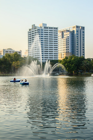 Beautiful fountains in the lake at Lumpini Park, Bangkok Thailand. Tranquil public park garden with pond, fountain, and boats in the middle of the city for people on holiday or after work leisured.のeditorial素材