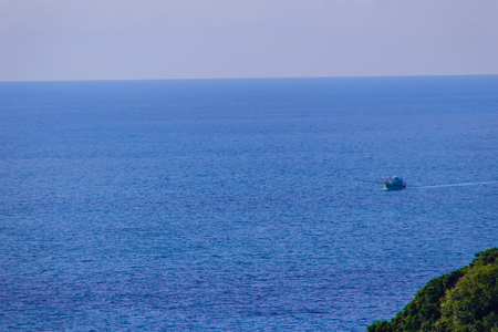 Colorful marine landscape with fisherman boat against deep blue sea under blue sky in the ocean on the cloudy day at Phuket, Thailand.の写真素材
