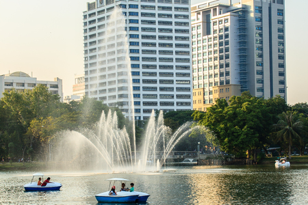Beautiful fountains in the lake at Lumpini Park, Bangkok Thailand. Tranquil public park garden with pond, fountain, and boats in the middle of the city for people on holiday or after work leisured.のeditorial素材