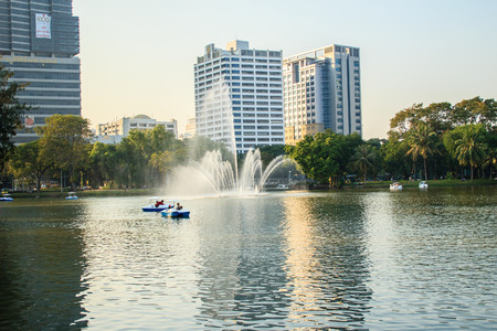 Beautiful fountains in the lake at Lumpini Park, Bangkok Thailand. Tranquil public park garden with pond, fountain, and boats in the middle of the city for people on holiday or after work leisured.のeditorial素材